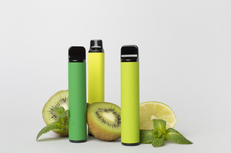 Disposable electronic cigarette with fruit on color background